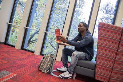 Student reading a book in the library